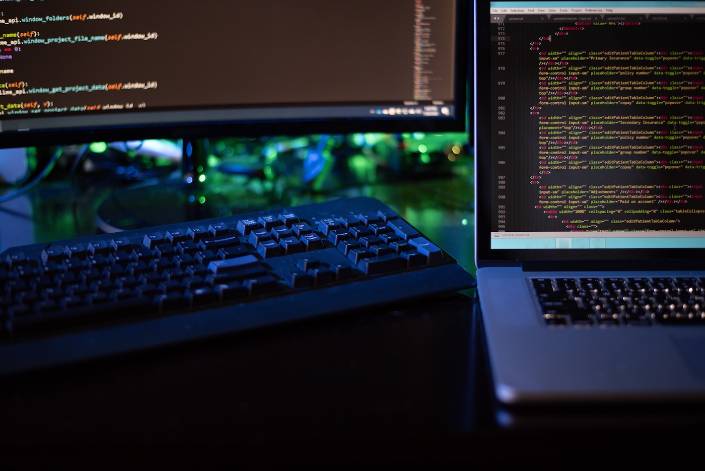 Website developer working with source code on computer screens