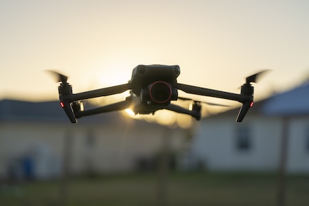 Drone silhouetted against sunset during an aerial filming session