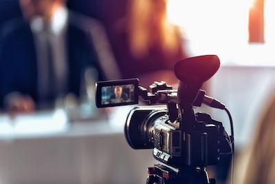 Professional camera recording a business event for commercial video production